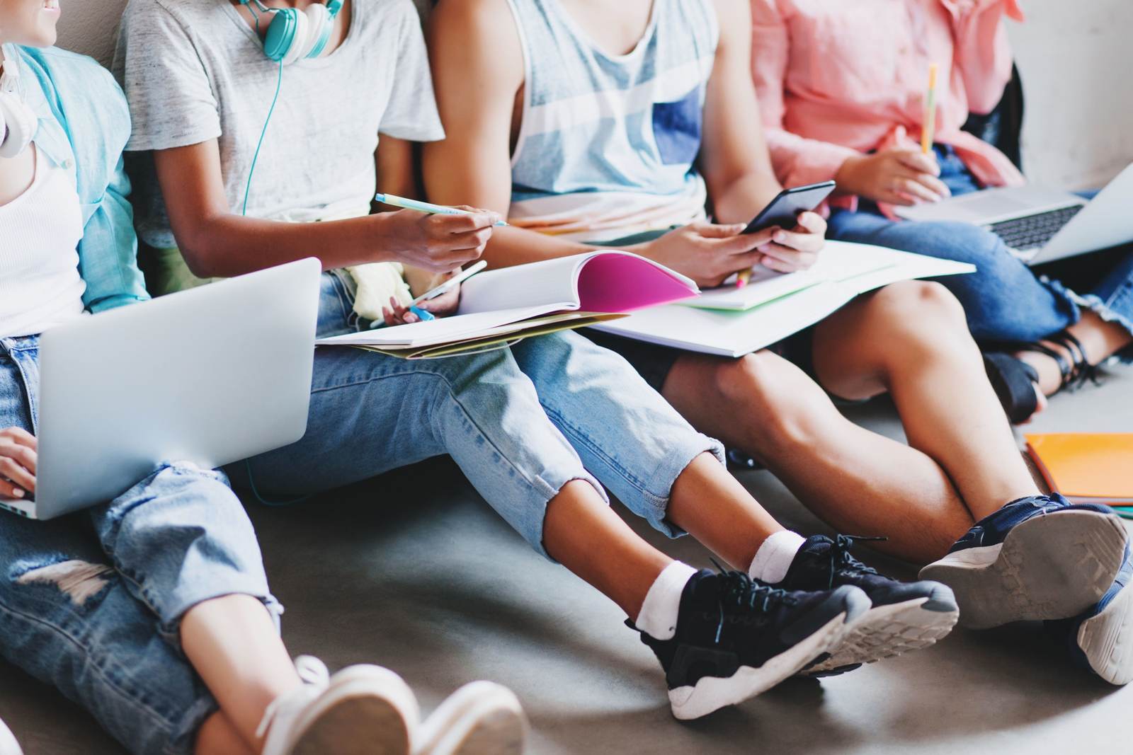 Studierende sitzen mit Laptops und Notizen zusammen und bereiten ihre Abschlussarbeit vor